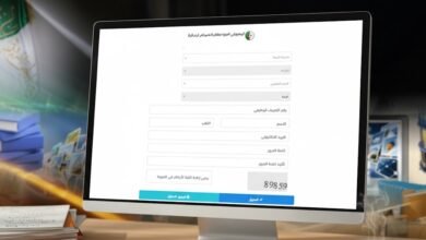 Use the provided reference image as the main visual reference. Generate an ultra-realistic landscape photograph (610x254) showing a computer or laptop screen displaying the Algerian "Espace Enseignants" (Teachers’ Space) portal, based on the referenced screenshot. Recreate the interface style, colors, and general layout from the reference image, but blur or abstract any readable text for privacy. The setting should depict a realistic teacher’s workspace: a wooden desk, papers, pen, and a cup of coffee or reading glasses nearby. Soft natural daylight, high realism, and a clean educational atmosphere. No watermark, no added text beyond what appears blurred on the screen, no visible faces.